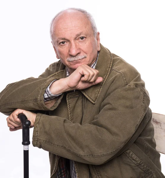 Sad lonely elderly man with a cane sitting  on a chair — Stock Photo, Image