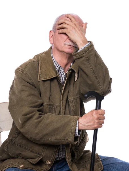 Triste homem idoso solitário com uma bengala sentada em uma cadeira — Fotografia de Stock