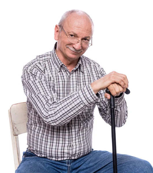 Happy elderly man in glasses with a cane sitting on chair — Stock Photo, Image