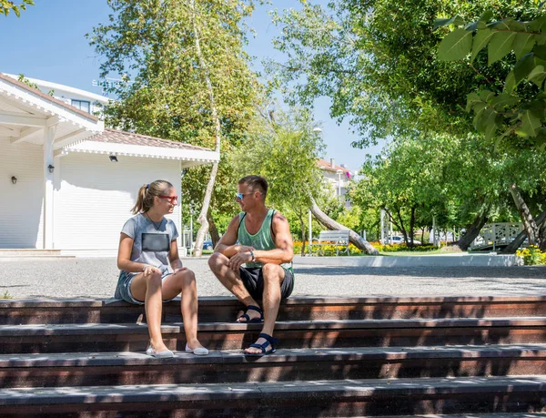 Far och tonårsdotter sitter på trappan i parken — Stockfoto