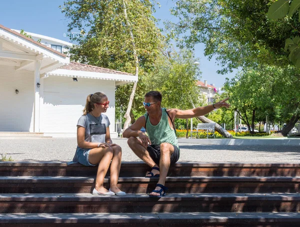 Father and teen daughter sitting on the stairs in the park — Stock Photo, Image