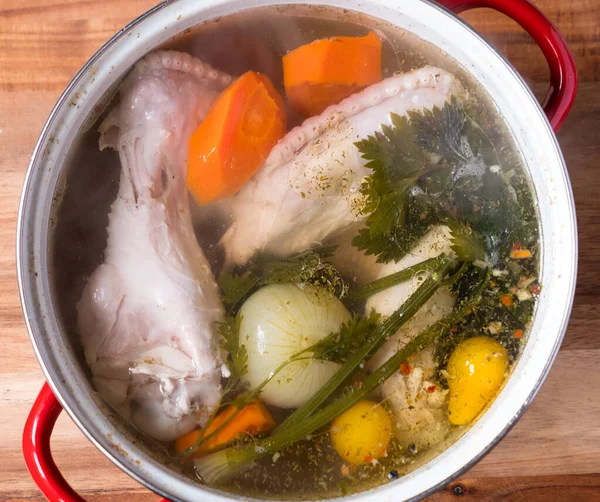 Turkey broth with pieces of meat on bone and vegetables in cooki — Stock Photo, Image