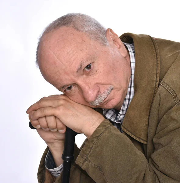 Грустный одинокий пожилой мужчина с тростью, позирующий в студии — стоковое фото