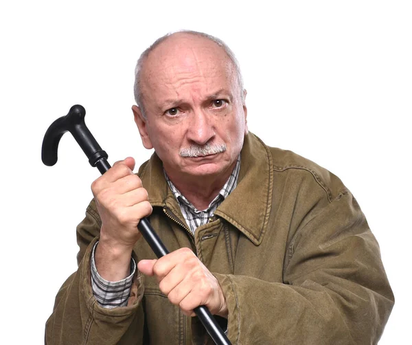 Old angry man threatening with a cane in studio — Stock Photo, Image