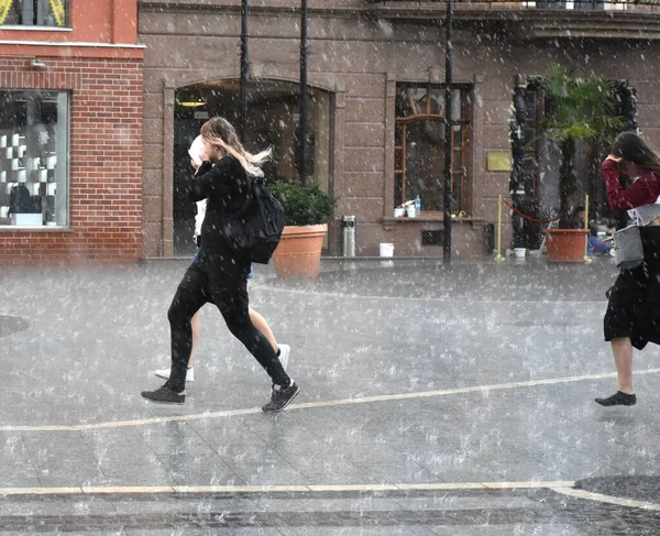 雨の日に人々が通りを走り回っている。意図的な動き — ストック写真