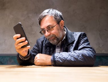 Üstün giysili adam cep telefonu kullanıyor.