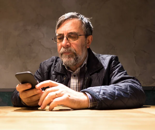 Homme âgé en vêtements décontractés en utilisant le téléphone mobile — Photo