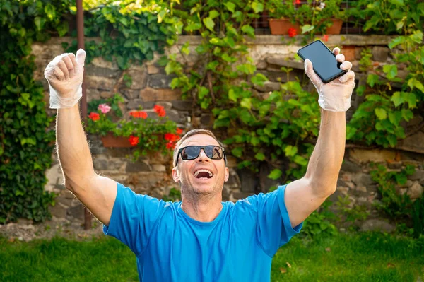 Smiling Man Disposable Gloves Holding Smartphone Outdoors — Stock Photo, Image