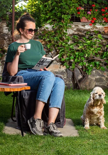 コーヒーを飲みながら庭でリラックスした笑顔の女性 — ストック写真