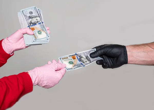 Mężczyzna Rękawiczkach Daje Paczkę Dolarów Kobiecie Rękawiczkach Szarym Tle — Zdjęcie stockowe
