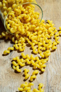 Cavatappi makarnası. Ahşap zemin üzerinde pişirilmemiş altın buğday kıvırcık makarna