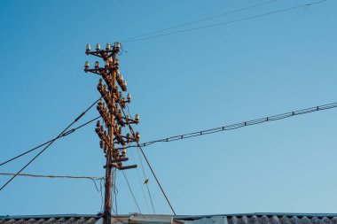 Mavi gökyüzüne karşı yüksek voltaj kabloları 