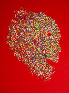 Çok renkli köpük toplarının arka plan dokusu. Parlak köpük topları. Kırmızı arkaplan üzerinde kafatası şekli