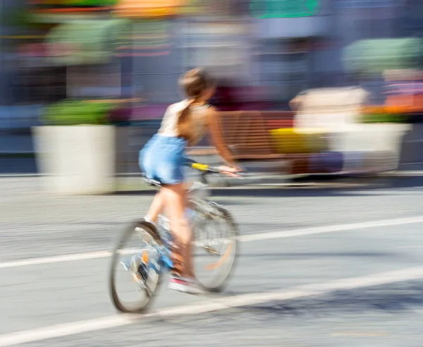 通りを自転車で移動中の女性 意図的な動きのぼかし 専用画像 — ストック写真