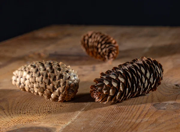 Drei Tannenzapfen Auf Einem Holztisch — Stockfoto