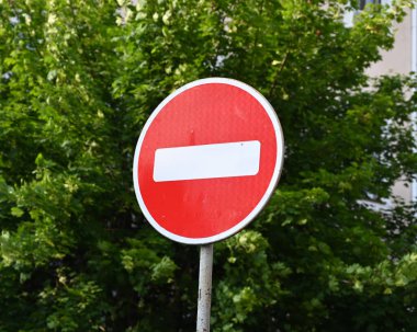 Şehir ortamında güneşli bir günde yeşil bir arkaplanda belirgin bir giriş işareti yok