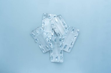 Mavi arka planda boş tablet paketleri. Tıbbi, çevresel konsept. Sağlık terapisi. Salgın, salgın, aşı..