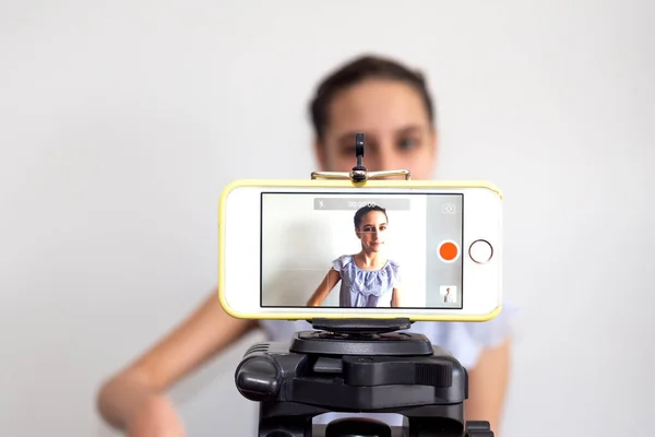 Teen girl blogger influencer recording video blog concept speaking looking at smartphone on tripod at home. Teenager social media vlogger shooting vlog, streaming online podcast on mobile phone. — Stock Photo, Image