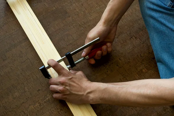 A hím kezek rögzítsék a fogót a fából készült sínekhez, és vágás előtt mérjék meg. Javítási koncepció — Stock Fotó