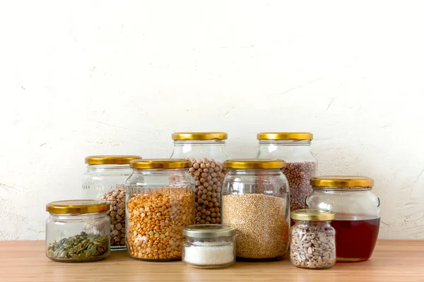 Organic bio bulk products in zero waste shop. Foods storage in kitchen at low waste lifestyle. Cereals and grains in glass jars on table. Eco friendly shopping in plastic free grocery store