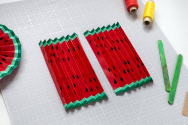 DIY talimatı. Adım adım özel ders. Yaz doğum günü partisi için dekorasyon yapıyorum. Kırmızı ve sarı karpuz fanı. El aletleri ve malzemeler. Beşinci adım..