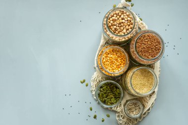 Sıfır atık dükkanında organik biyokütle ürünleri. Mutfaktaki yiyecek deposu düşük atık yaşam tarzında. Masadaki cam kavanozlarda tahıl ve tahıllar. Plastik ücretsiz bakkaldan çevre dostu alışveriş.