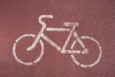 Kırmızı bisiklet yolunda beyaz boyalı bisiklet tabelası