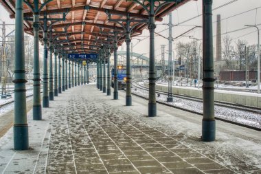 Tren tren istasyonuna girer, çatıdaki platformda kar fırtınası, dakik ve gecikmiş trenlerle kaplıdır.