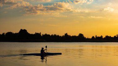 Gün batımında Vistula Nehri üzerinde Polonya Kano kadın.