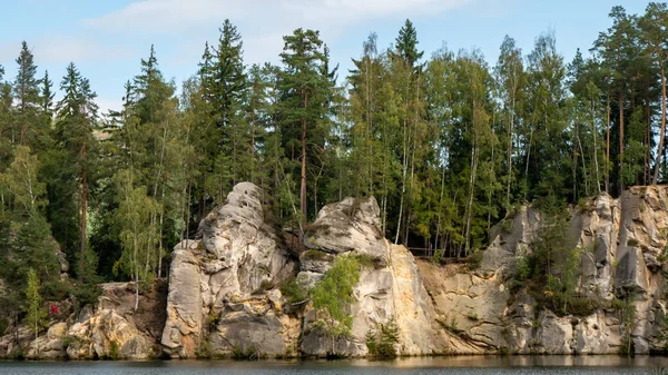Lake and ancient pines growing between them located in rock city Adrspach, National park of Adrspach, Czech Republic