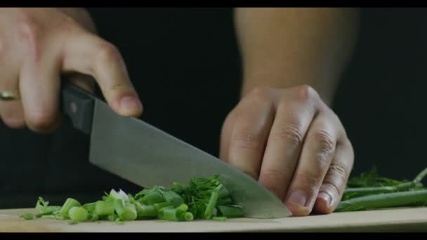 一个男子厨师切割蔬菜像洋葱和香菜在砧板上的射击 — 图库视频影像