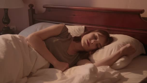 Красивая Молодая Женщина Просыпается Растягивается Своей Кровати Теплых Утренних Огней — стоковое видео