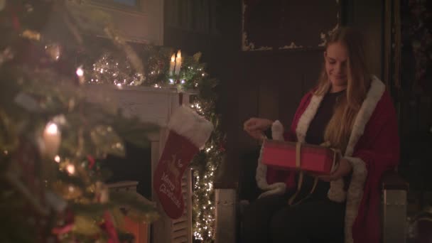 Mignonne Fille Assise Côté Arbre Noël Regardant Heureux Tout Ouvrant — Video
