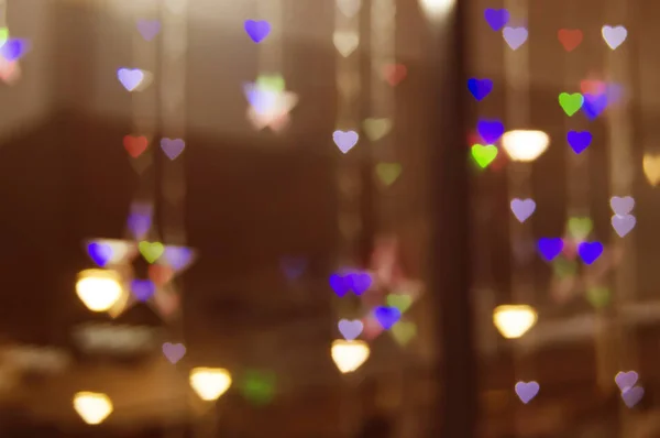 Дефокус боке гирлянда сердце в витрине магазина блики текстуры фона — стоковое фото