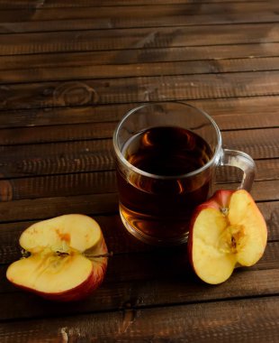 Bardak elma sirkesi ve bir elma iki yarısı.