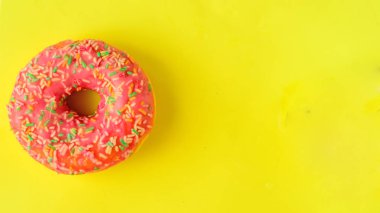 Pastel sarı zemin üzerine pembe çörek. Tatlı çörek. Flatlay.Copyspace sağ