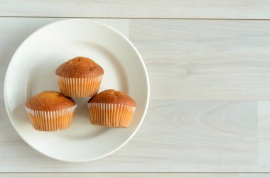 Üç muffins beyaz tabakta. Şekerli tatlı.