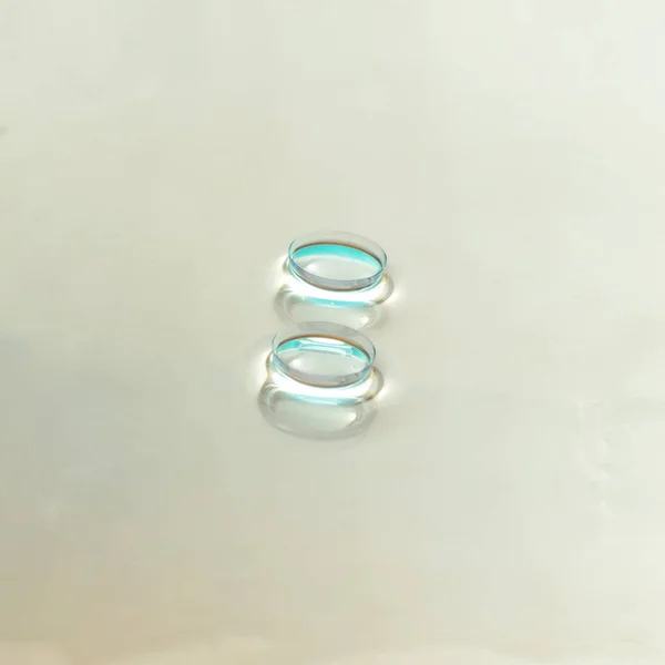 Two contact lenses on glass background.Square frame.