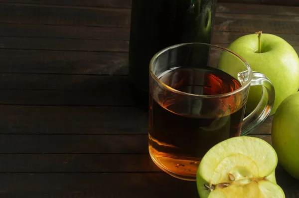 Un vaso de vinagre de manzana con manzanas verdes sobre fondo de madera, espacio para texto — Foto de Stock