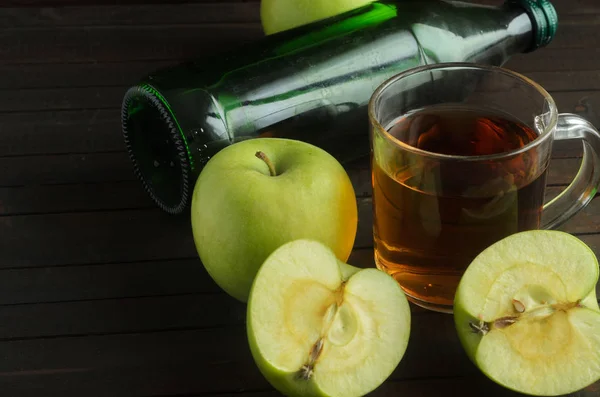 Un vaso de vinagre de manzana con manzanas verdes y la botella de sidra sobre fondo de madera, espacio para el texto — Foto de Stock