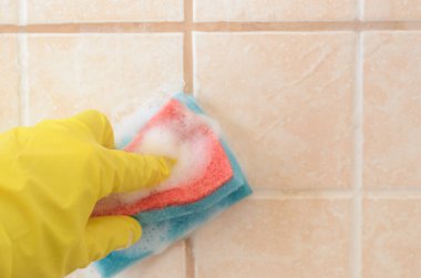 sünger ile sarı koruyucu eldiven el yıkama köpük ile seramik karolar yıkar. Erken bahar temizliği veya düzenli temizlik. Sağdaki metin için alan.