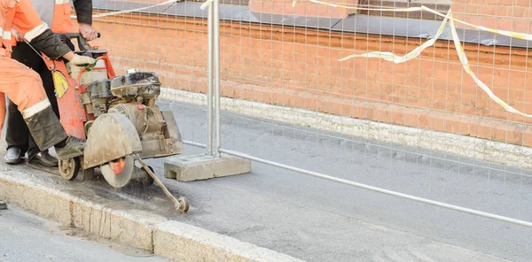 Straßenarbeiter beim Schneiden der Asphaltstraße, Arbeiten am Wiederaufbau der Straße.. Stockbild