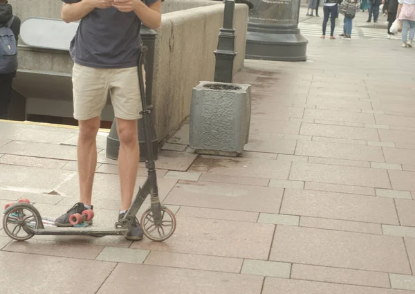 O cara com scooter em pé no pavimento. — Fotografia de Stock