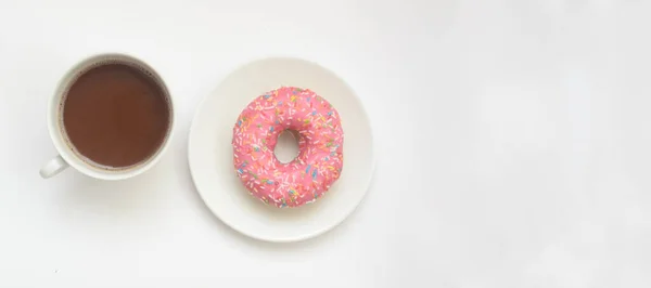 Uma xícara de cacau e donut rosa no fundo branco, espaço para texto — Fotografia de Stock