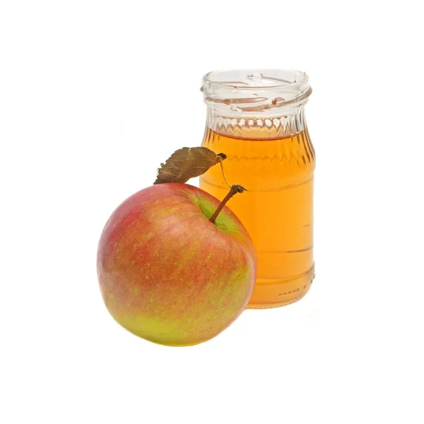 Una manzana entera con hoja y una pequeña botella de vinagre de sidra de manzana aislada sobre fondo blanco. — Foto de Stock