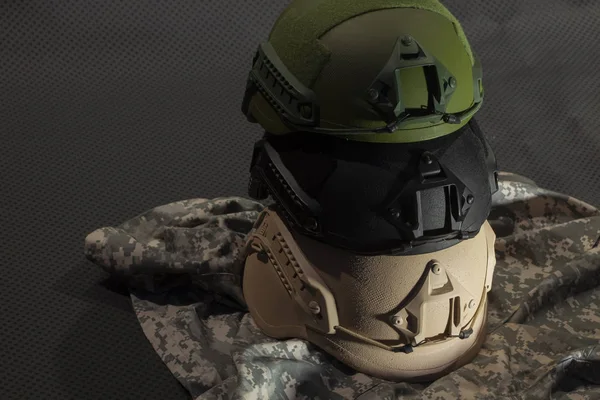 three nato military helmet on camouflage background