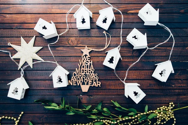 Bir Noel ağacı delik ve ışık içinde ve orta paslı ahşap arka plan üzerinde Konsept ev tatil için bir Noel dekorasyonu ile küçük bağlantılı metalik evlerin Noel dekorasyonu yapılan