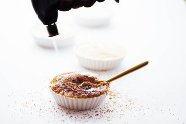 Beyaz bir arka plan üzerinde yanan meşale ile krem brulee üstüne caramelising şeker