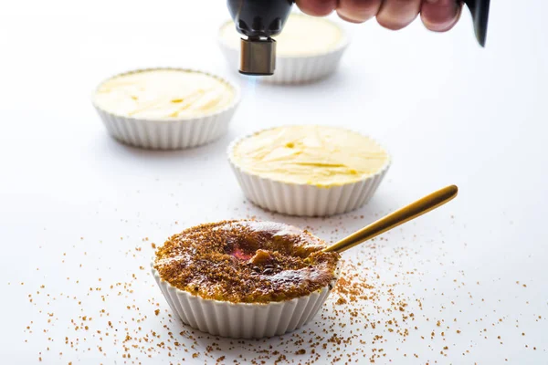 Caramelising Socker Ovanpå Crème Brûlée Med Brinnande Fackla Vit Bakgrund — Stockfoto