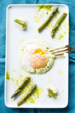 Sous vide haşlanmış yumurta mükemmel tutarlılık için 64,5 derece pişmiş, bir kuşkonmaz püresi ve kuşkonmaz kökleri ile bir çanak dikdörtgen beyaz, düz, üst görünümü, gurme gıda